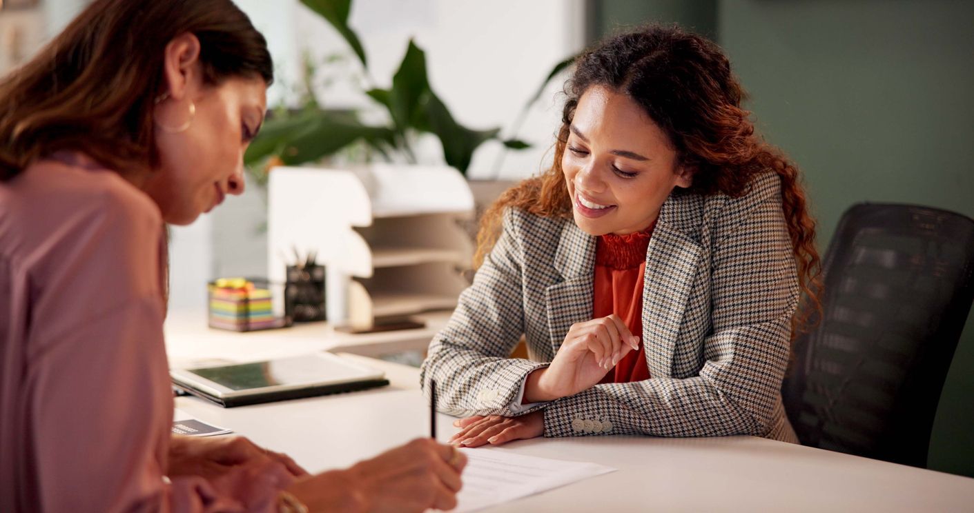 A long-term disability lawyer in Ontario sits at a desk in an office setting, consulting with a client about a disability claim.