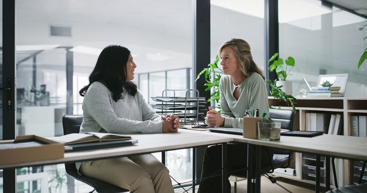 Two employees engage in a serious discussion in an office setting,