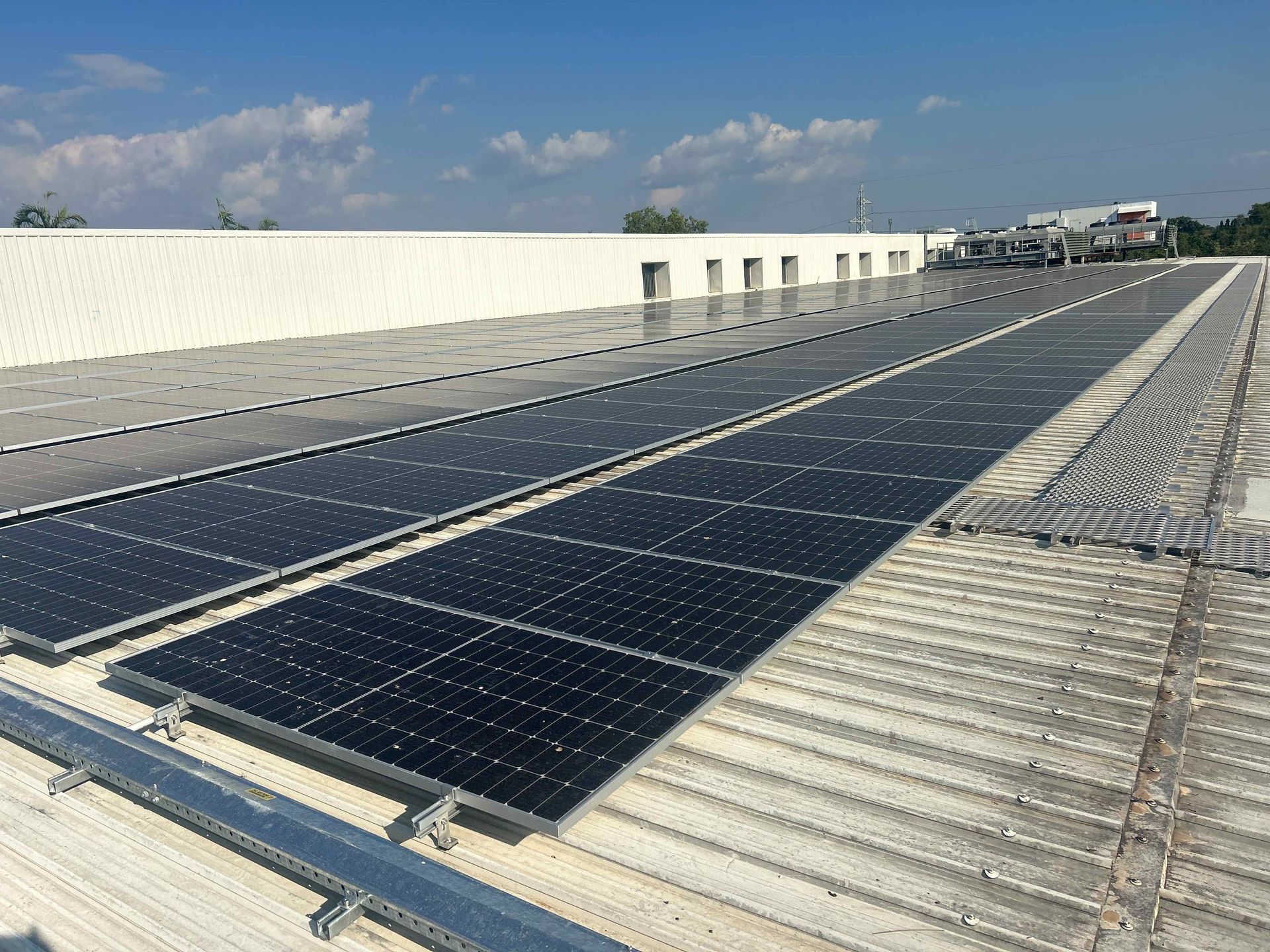 A Row of Solar Panels on A Roof with The Sun Shining Through Them — Eco Sparks Solar & Electrical Contractors in Berrimah, NT