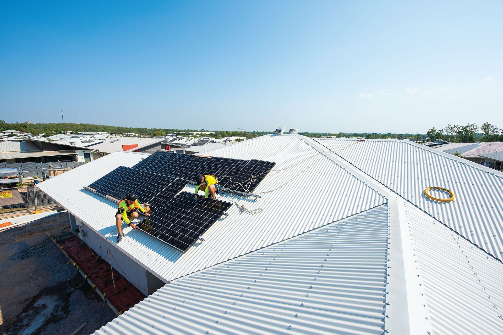 A Professional Group of Men Are Installing Solar Panels on A Roof — Eco Sparks Solar & Electrical Contractors in Berrimah, NT