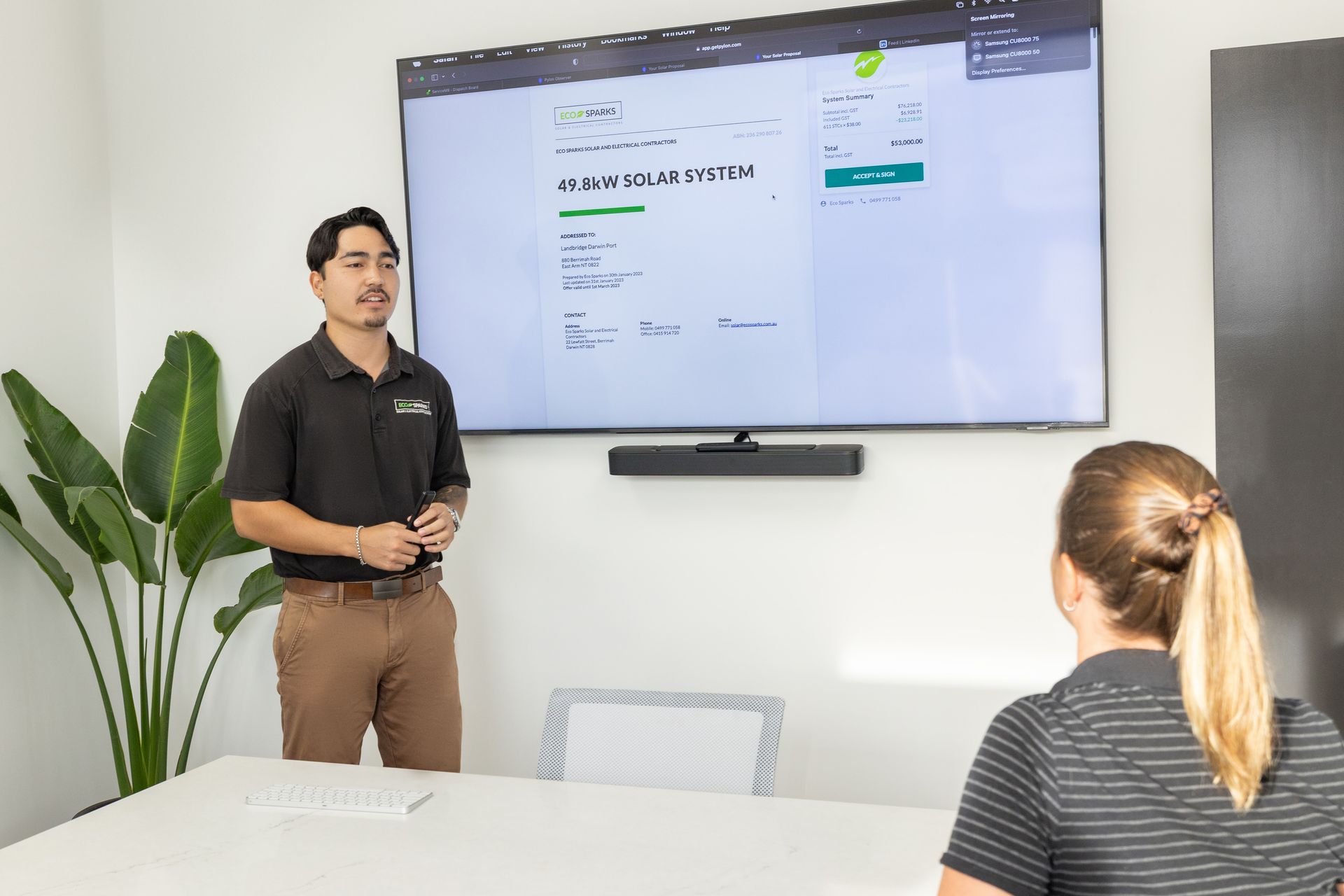 A Man Is Working on A Solar Panel in A Field — Eco Sparks Solar & Electrical Contractors in Berrimah, NT