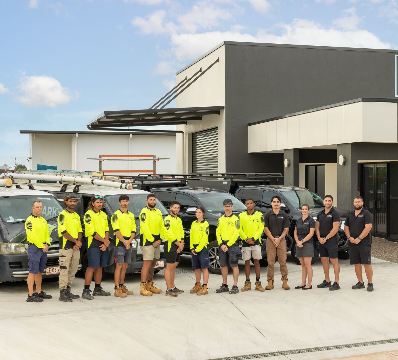 A Group of Professional Eco Sparks Workers Are Posing for A Picture in Front of A Van — Eco Sparks Solar & Electrical Contractors in Berrimah, NT