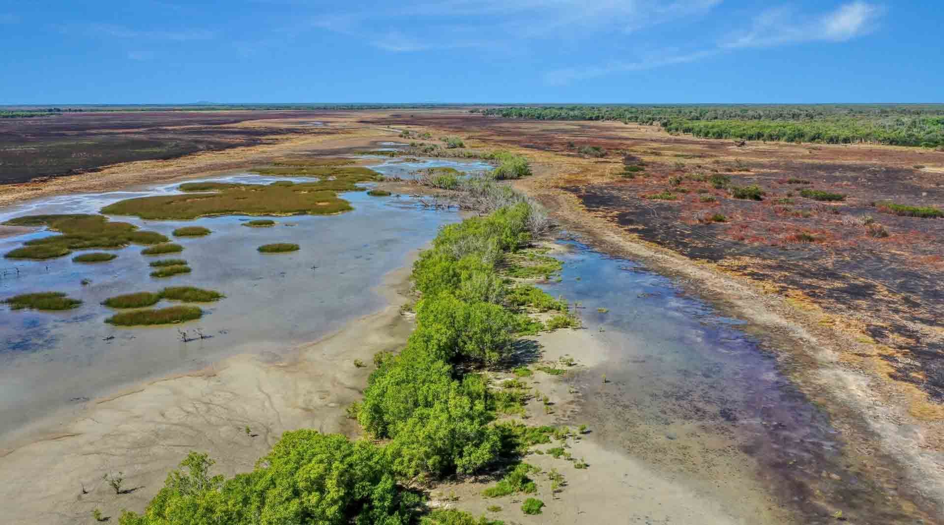 An Aerial View of a Swamp With Trees and a River — Eco Sparks Solar & Electrical Contractors in Humpty Doo, NT