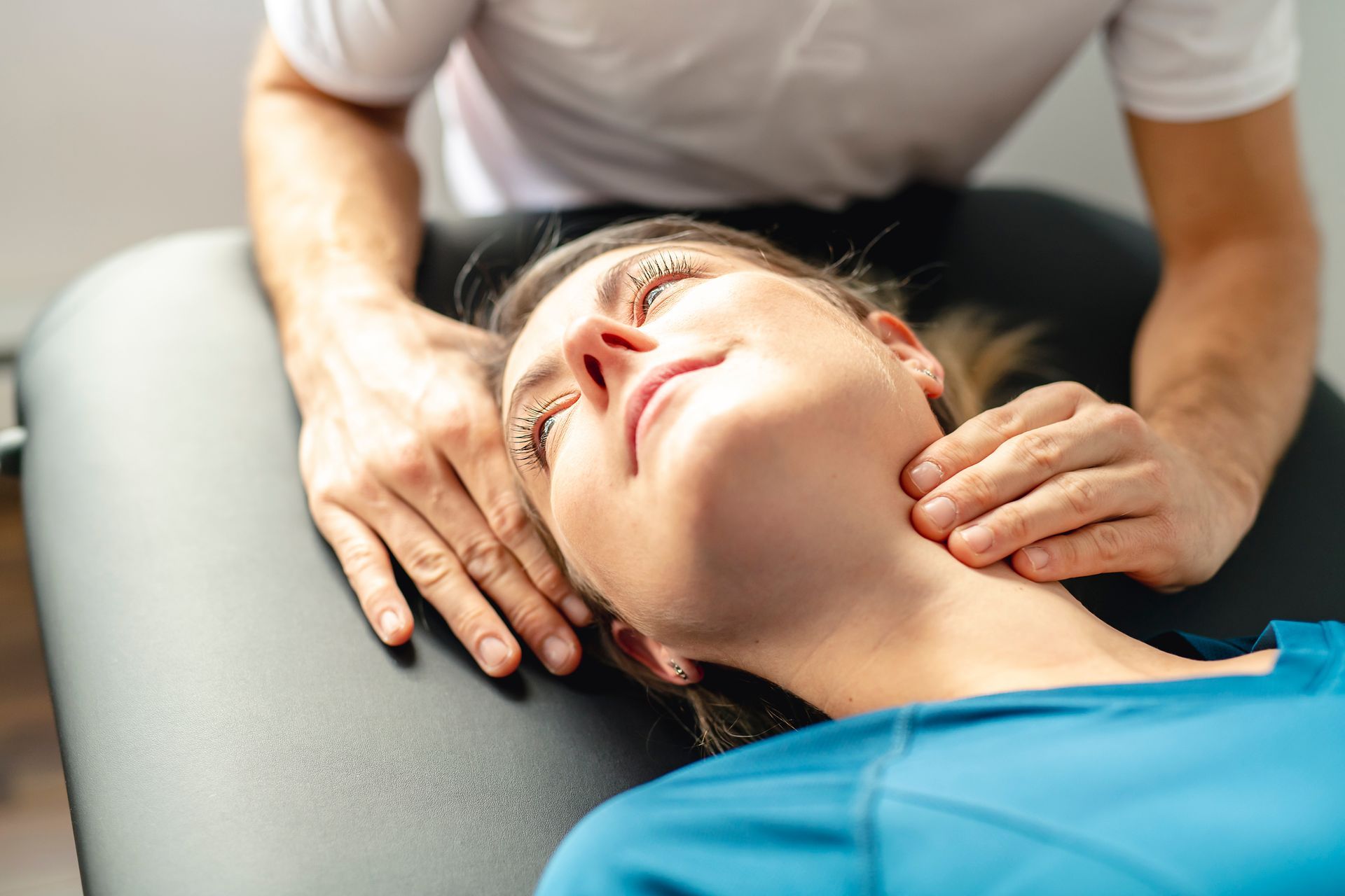 A Modern rehabilitation physiotherapy man at work with woman client woking on neck.