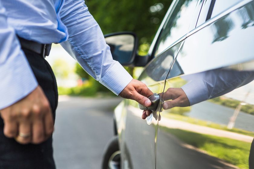 A man is opening the door of a car.