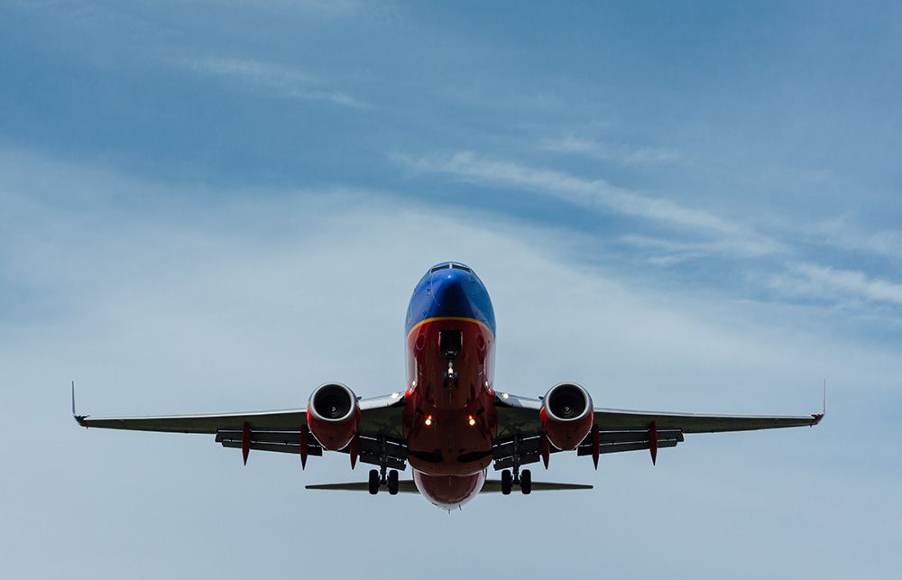 A large passenger jet is flying through a clear blue sky.