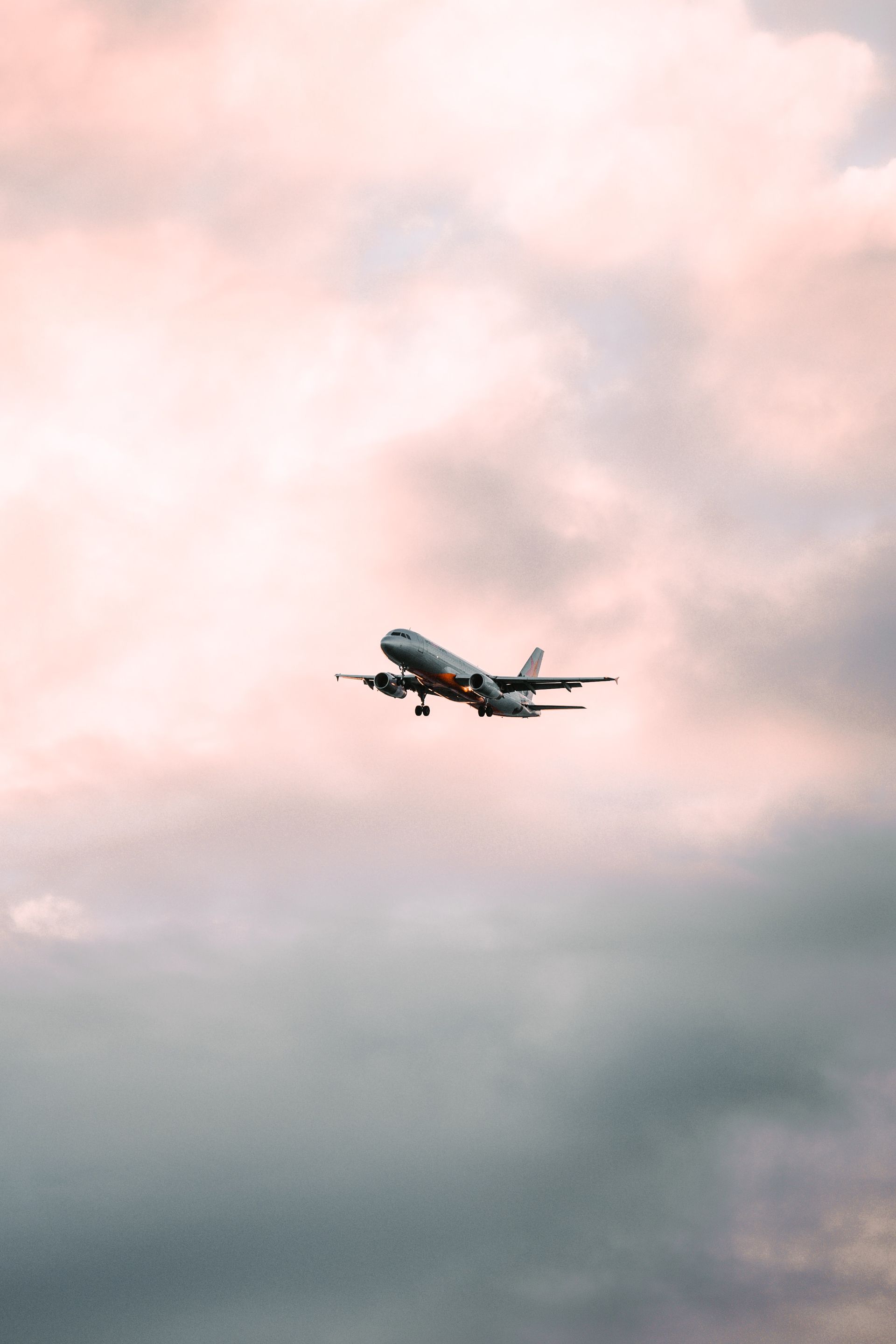 A large passenger jet is flying through a cloudy sky.