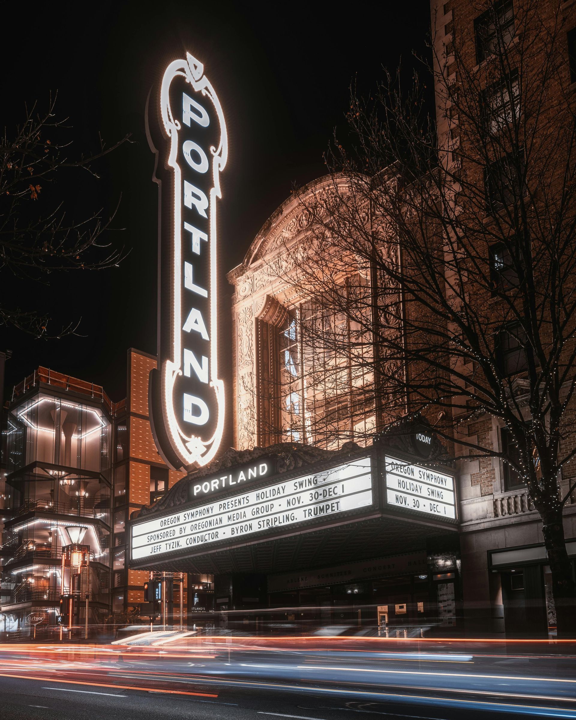 A large neon sign for portland is lit up at night.