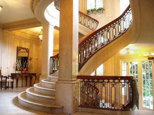 A spiral staircase with a wrought iron railing in a house