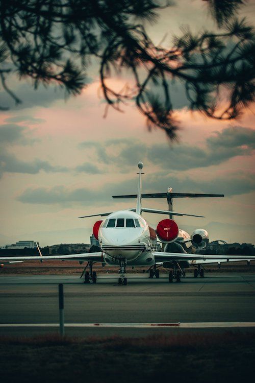 A small private jet is parked on the runway at an airport.