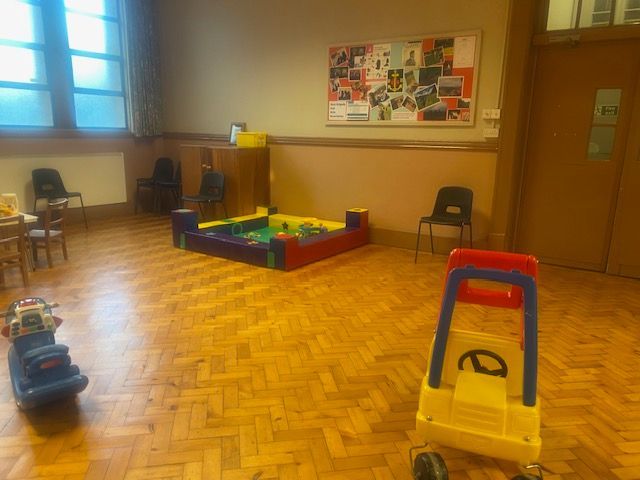 A room with a bulletin board and toys on the floor