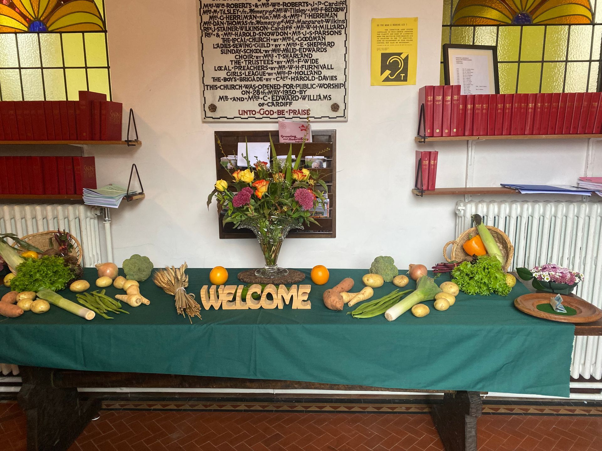 A table with vegetables and a welcome sign on it