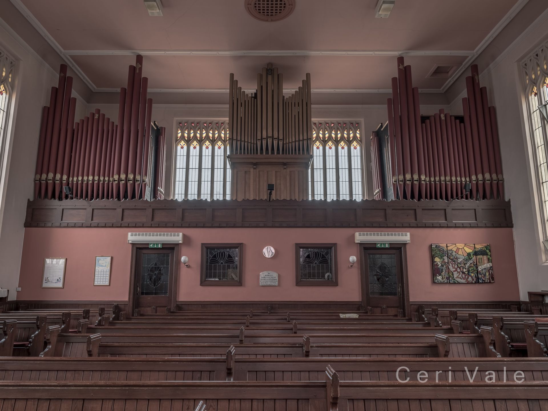 The inside of a church with a large organ in the middle