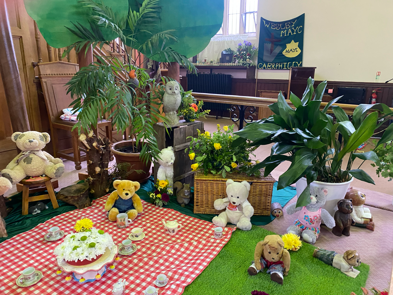 A picnic table with teddy bears and plants on it