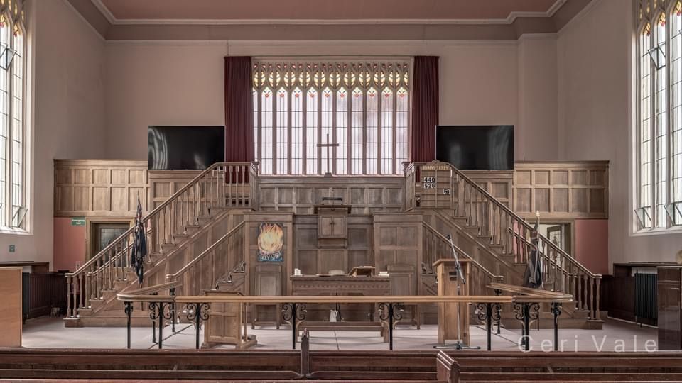 The inside of a church with a podium and stairs leading up to it.