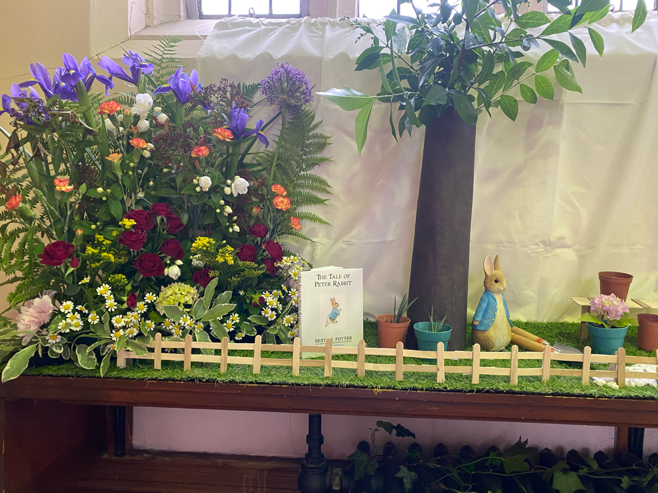 A display of flowers and a peter rabbit figurine