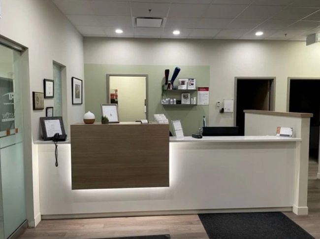 Modern reception desk in a clean office lobby with white walls and wood accents