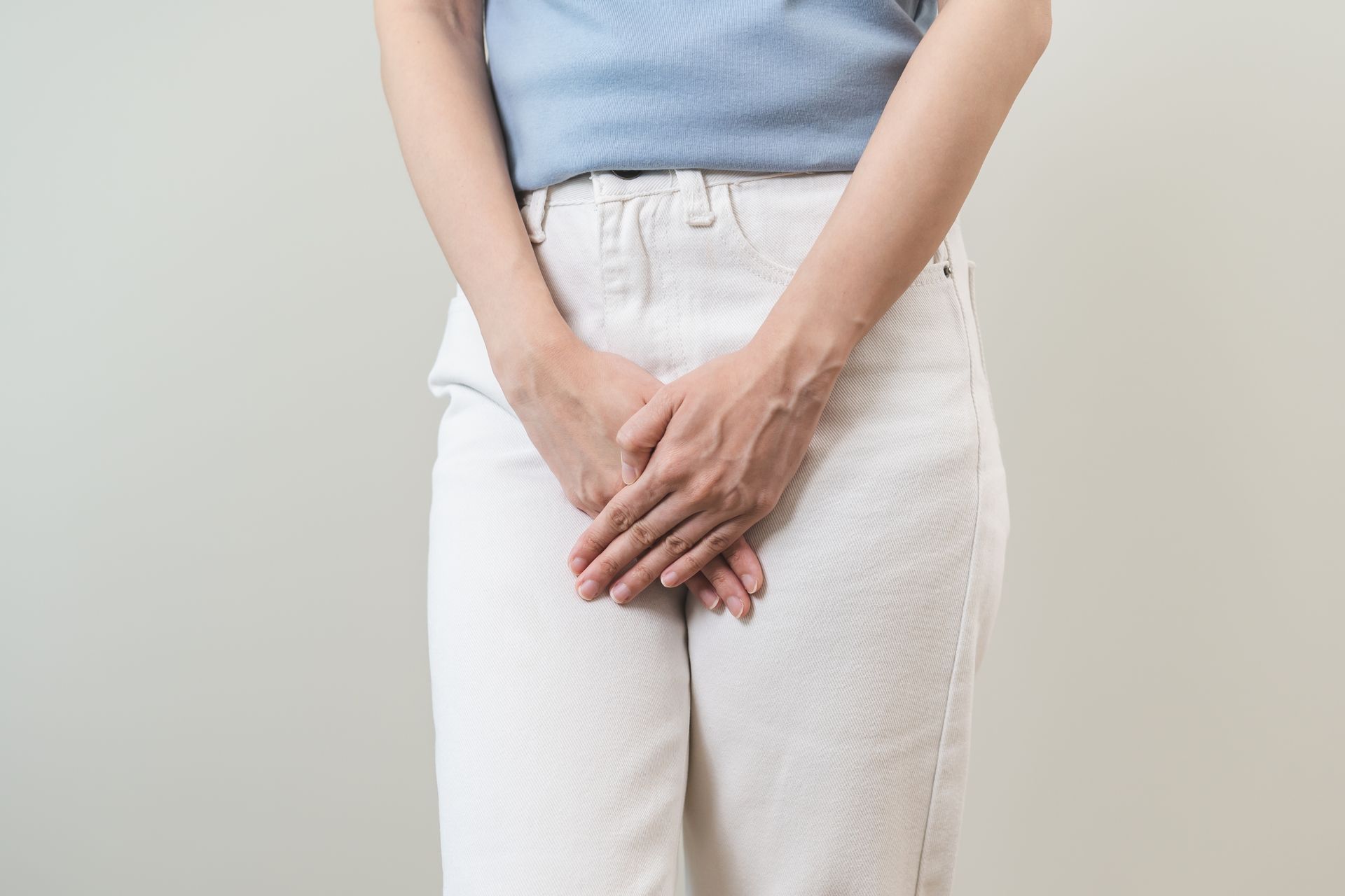 Hands holding and examining a bare foot with toes visible on a white background