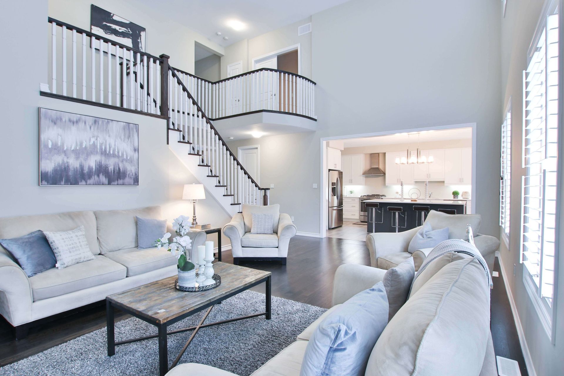 A living room filled with furniture and a staircase leading to the second floor.