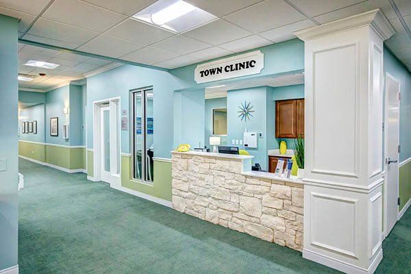 Hallway and reception desk in a clinic, featuring a stone front counter and 