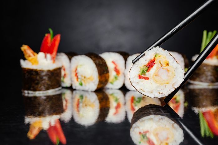 Chopsticks holding Roll Sushi — Vineland, NJ — Tang Asian Cuisine
