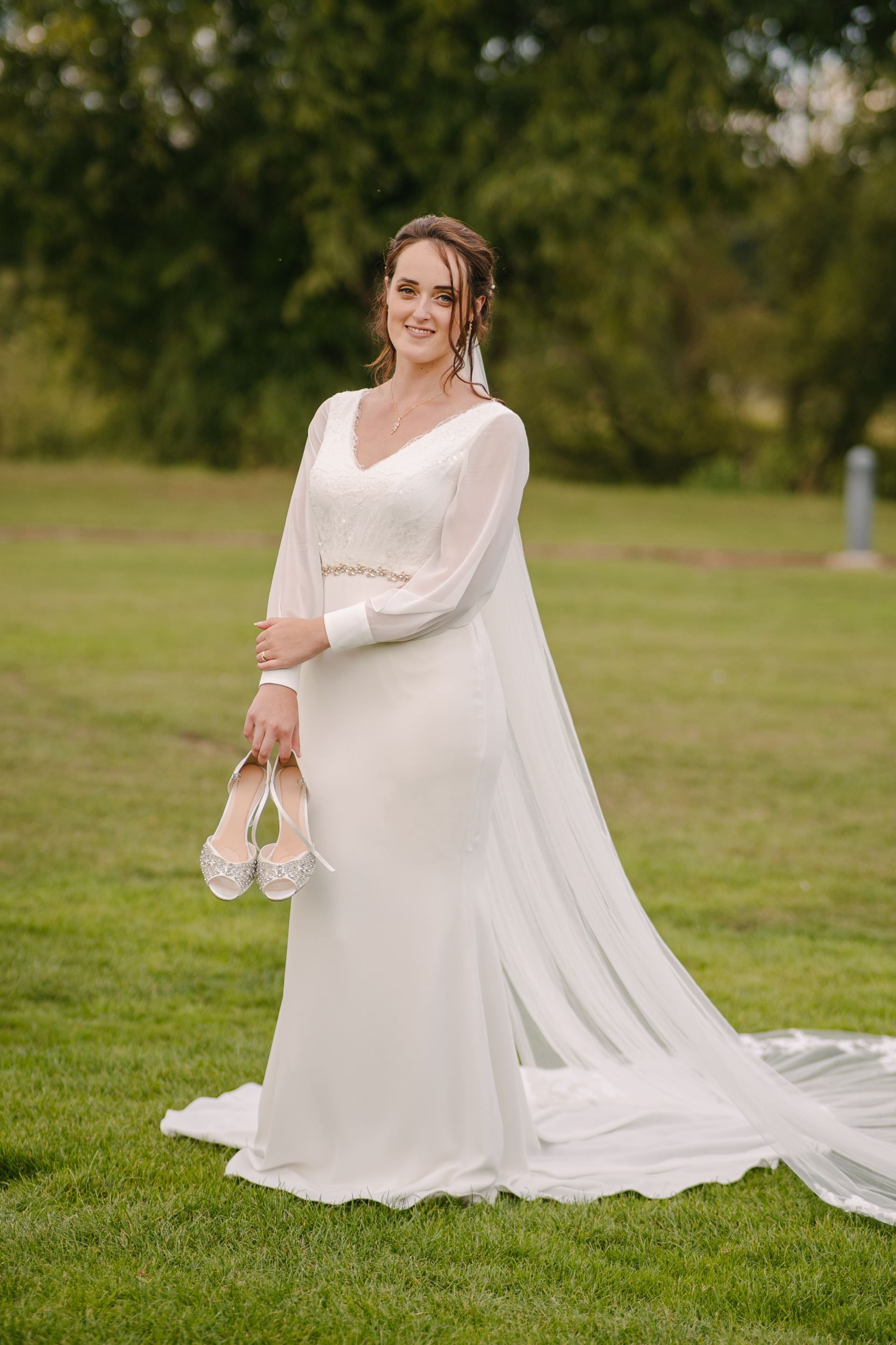 bride stood next to the river Avon holding her wedding shoes in Stratford upon Avon 