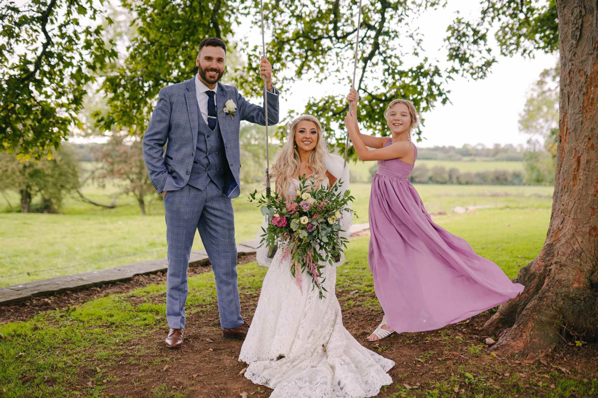 groom, bride and bridesmaid on a swing 