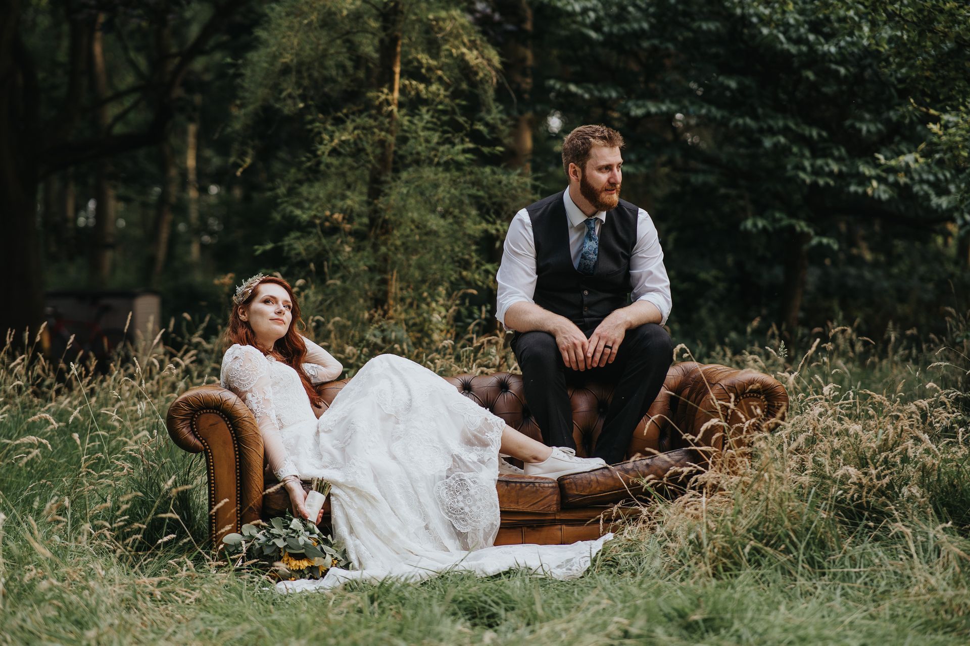 bride and groom alternative wedding portrait on brown leather sofa 