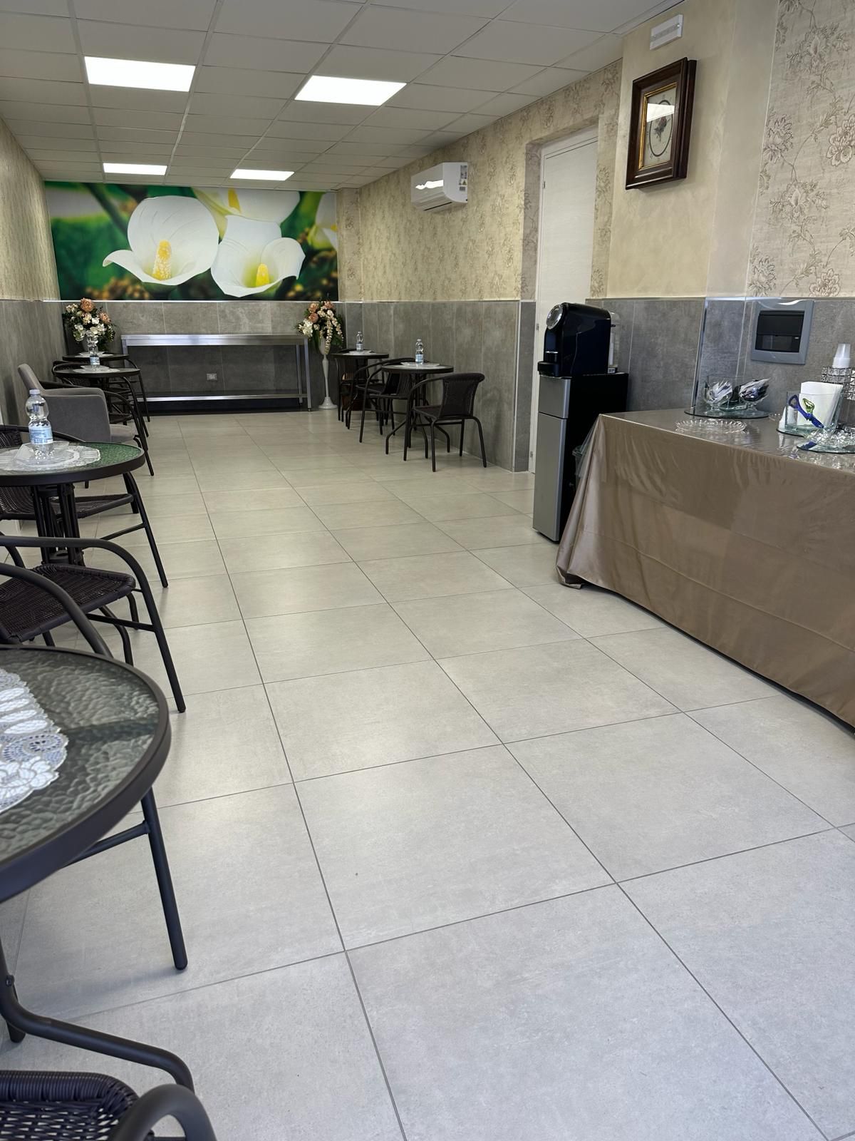 Un lungo corridoio con tavoli e sedie casa funeraria uva