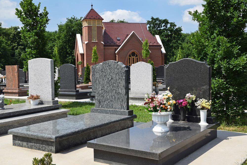 Un cimitero con tombe e una chiesa sullo sfondo