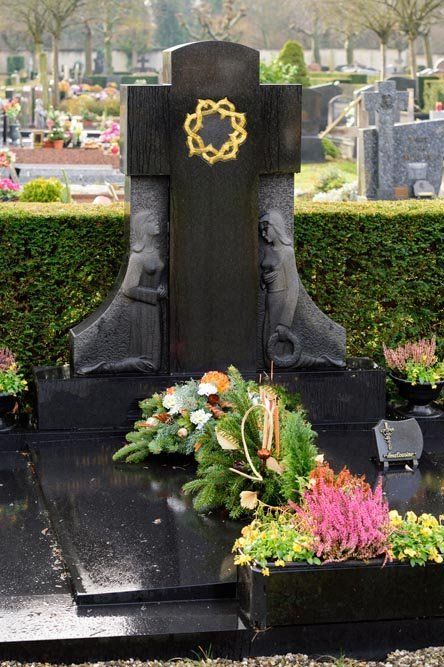 Una tomba con fiori e una croce sopra