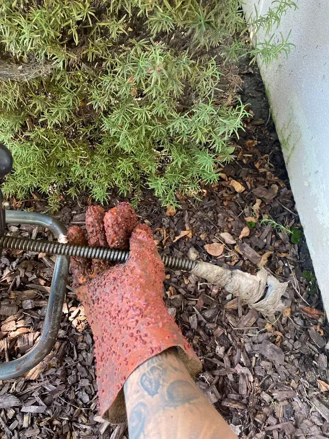A Person Wearing a Red Glove Is Holding a Hose in Their Hand.