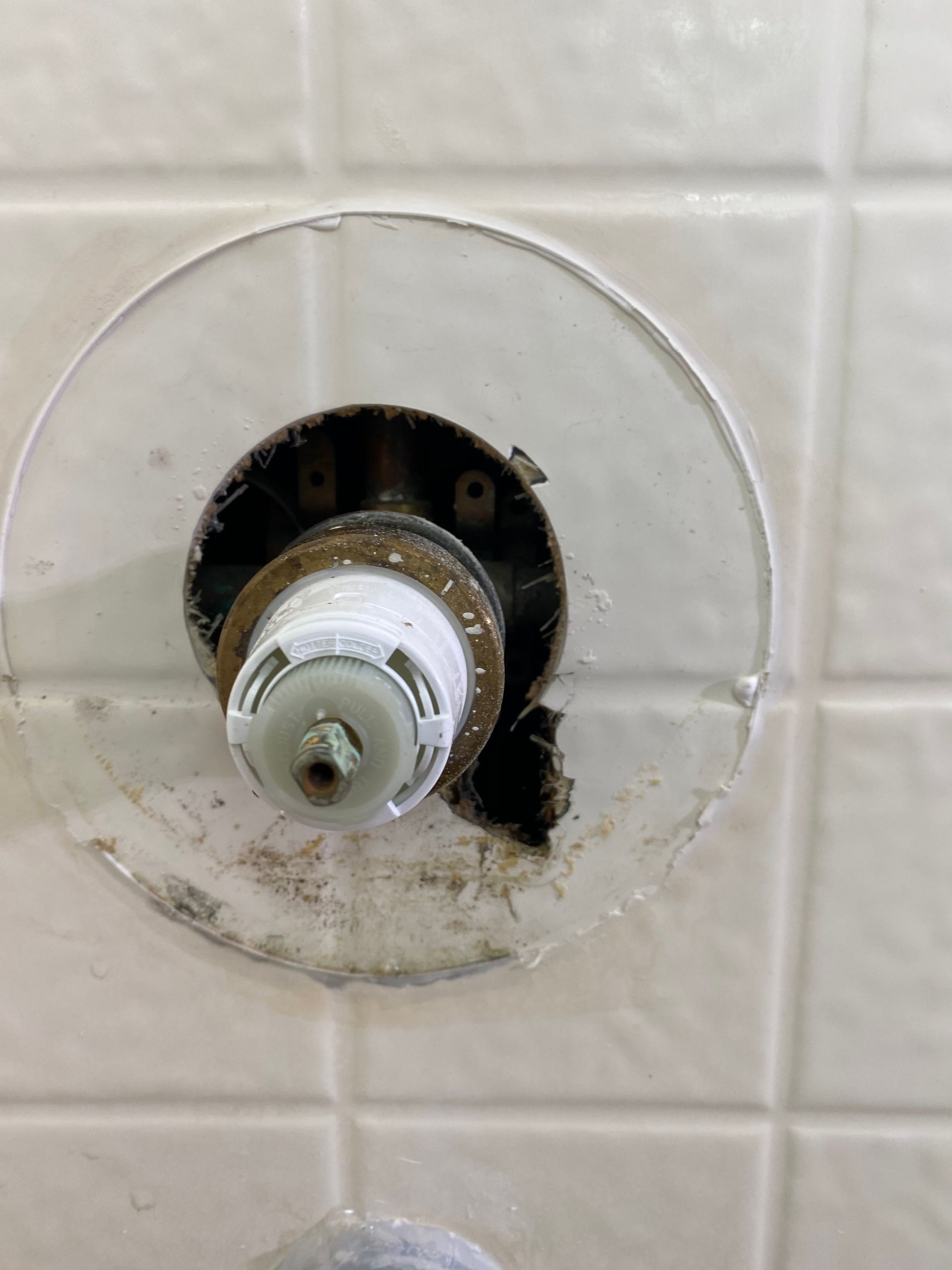 A Close up Of a Shower Head with A Hole in The Wall.