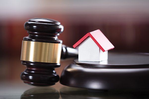 Close-Up of Gavel with Small House Model in Courtroom — Elmira, NY — Hutchison & Bocek