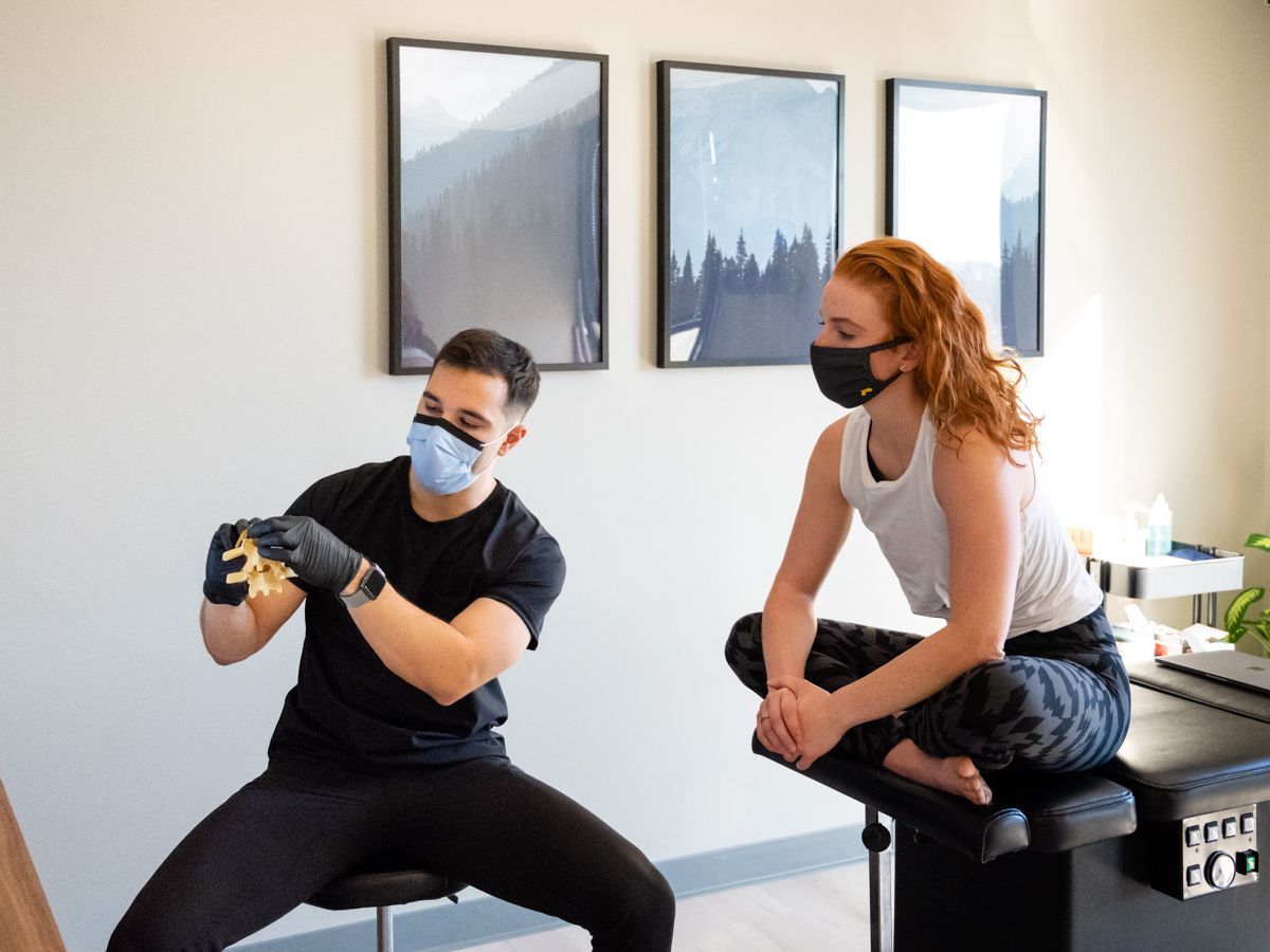 a man in a blue scrub is giving a man a neck massage .