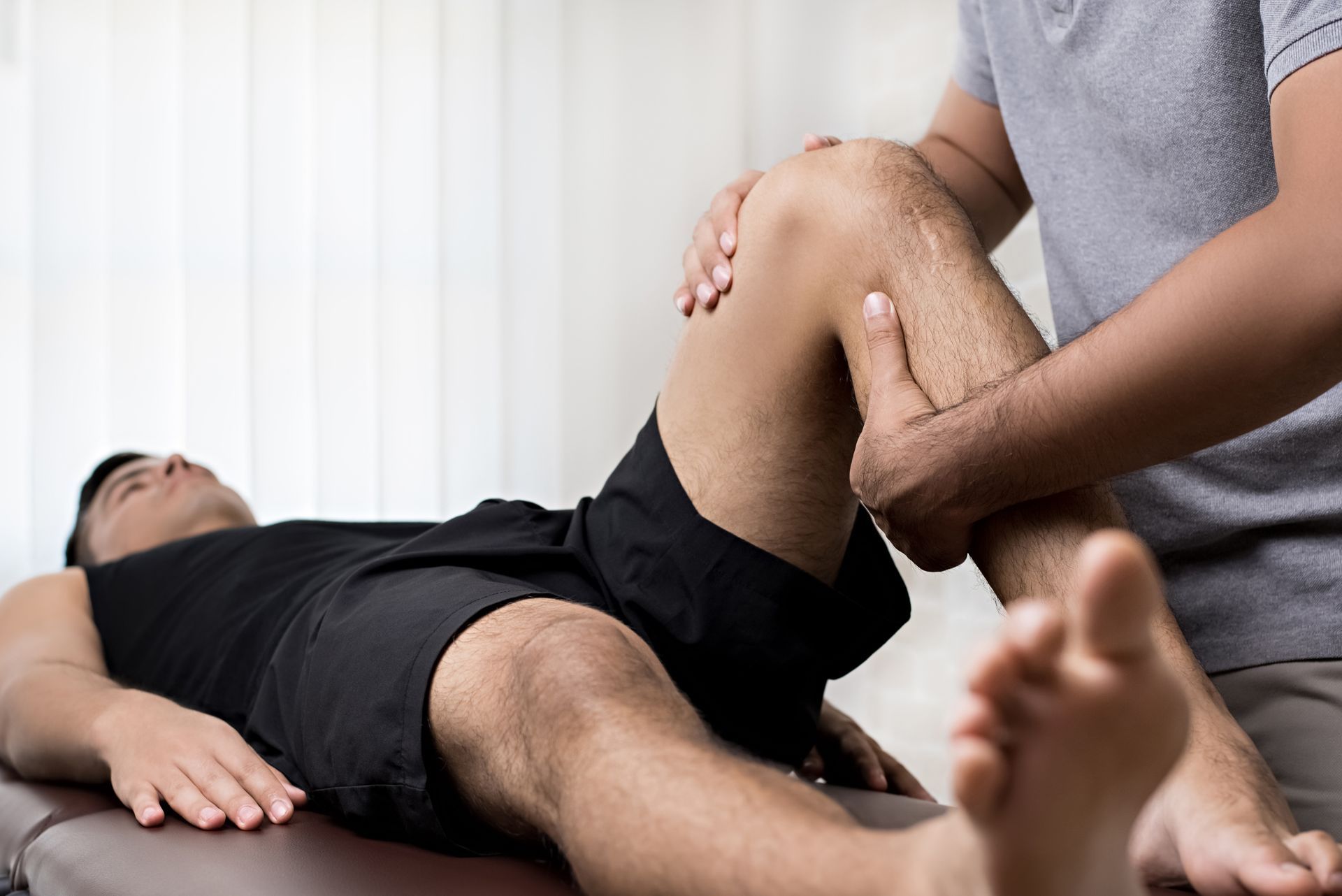 a man is getting a knee massage from a doctor .