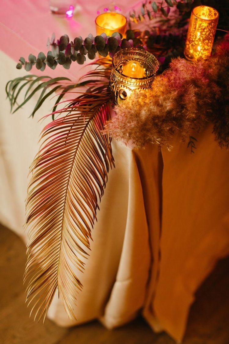 A table with a palm leaf and candles on it.