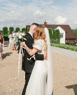 A bride and groom kissing in front of a house