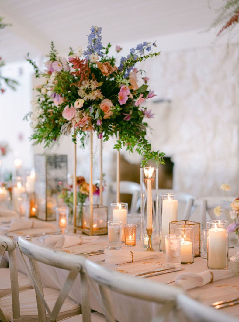 A long table with candles and flowers on it.