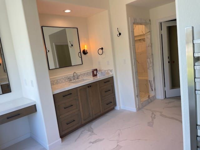 Bathroom with wood vanity, large mirror, and marble floor.