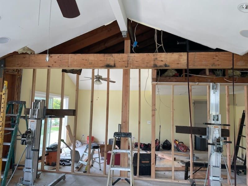 Interior wall studs with a wooden beam overhead during construction.