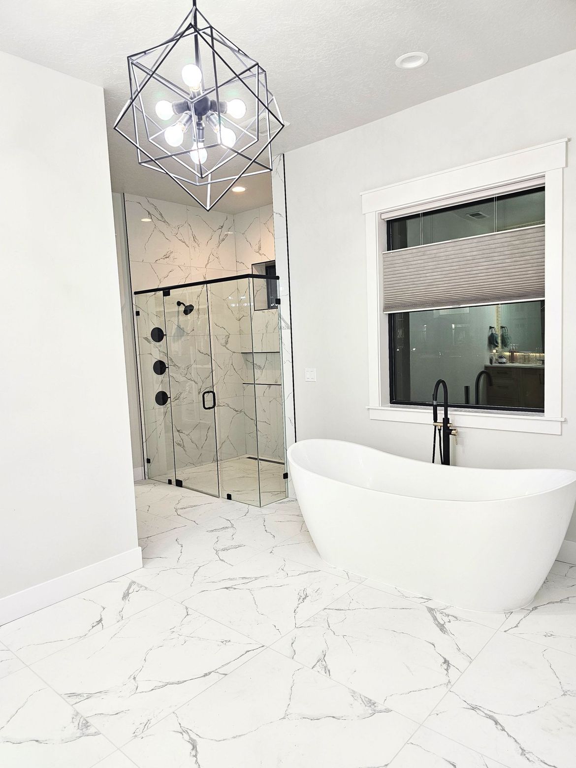 A bathroom with a tub , shower , and window.