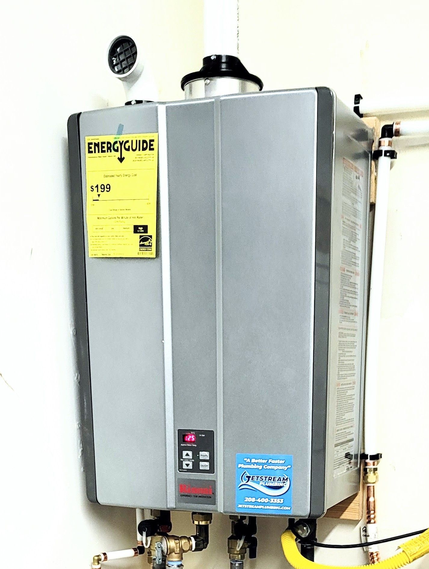 A gray water heater is hanging on a white wall.