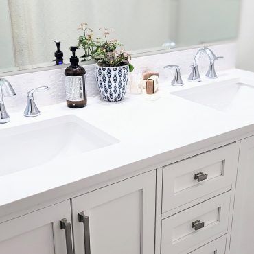 A bathroom vanity with two sinks and a mirror.