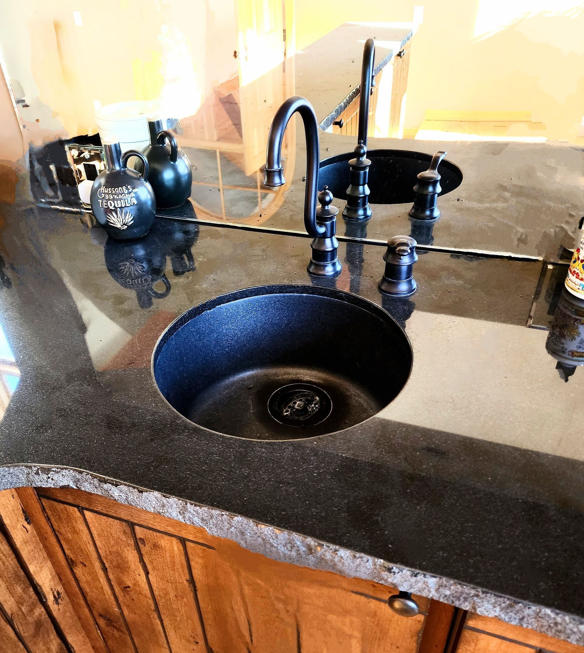 A kitchen counter with a sink and a mirror