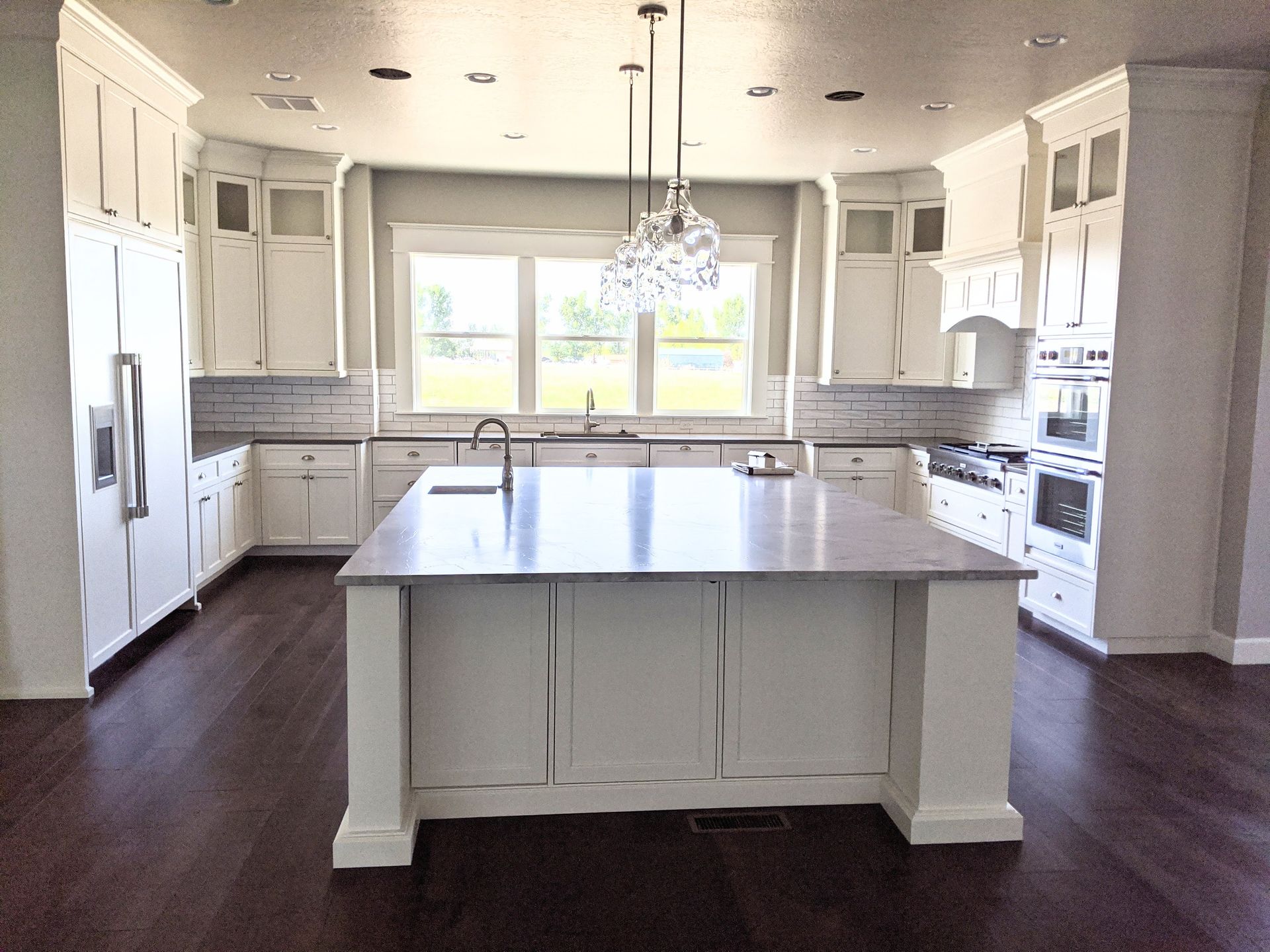 A kitchen with white cabinets and a large island