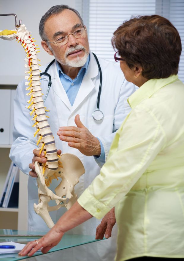 Chiropractic Center Near Me — Doctor Pointing Anatomical Spine in Vancouver, WA