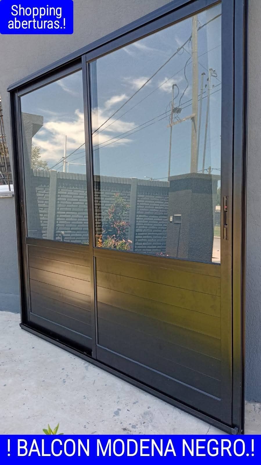 Puerta corredera de cristal negra con marco negro. Etiqueta "Balcón Módena Negro".
