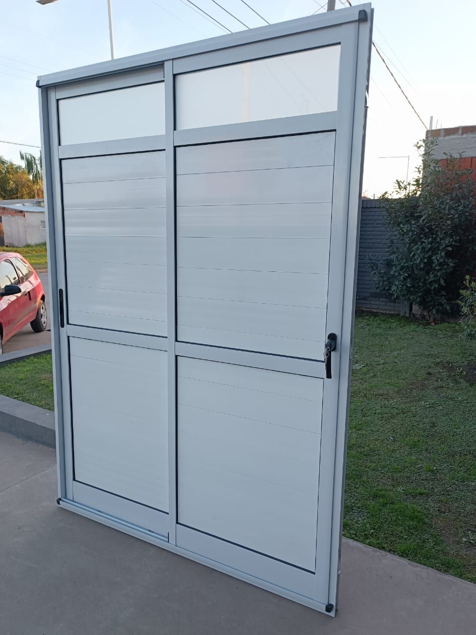 Puerta corrediza de vidrio blanco con paneles esmerilados.