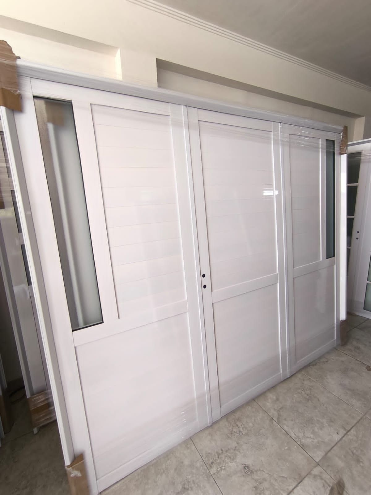 Puerta corredera blanca con marco de aluminio.